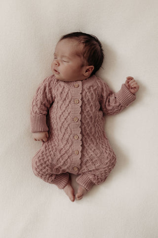 Newborn baby wearing cable knit romper in pink