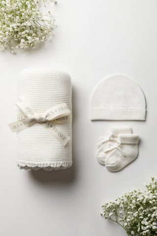 White knitted baby blanket, hat and booties