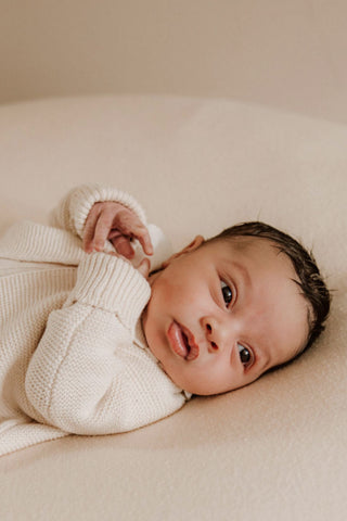 Baby wearing beige knitted cardigan