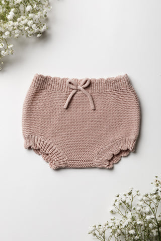 Knitted pink baby bloomers with a bow and a scalloped edge 