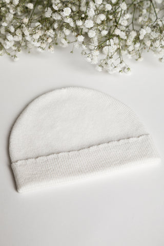 white knitted baby hat on white background