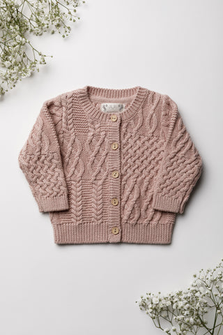 Cable Knit Pink Baby Cardigan on white background with gypsophilia