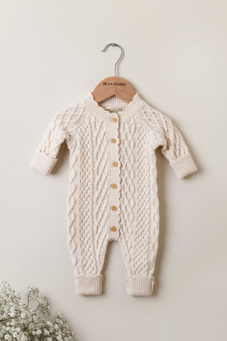 Cable Knit Baby Romper on a wooden Isla and Fraser Hanger 