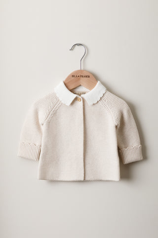 Knitted Baby Cardigan with Scallop Collar on a wooden Isla & Fraser hanger