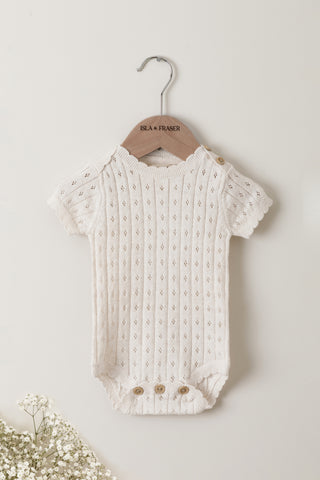 Pointelle knit baby bodysuit on a wooden Isla & Fraser hanger