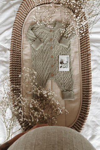 Knitted Sage Baby Romper in Changing basket with polaroid and baby bump