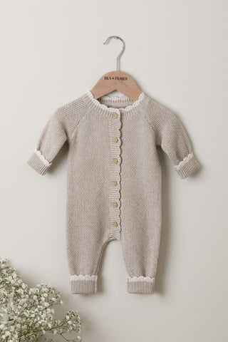 Knitted baby romper in grey with cream scallop detail on an Isla & Fraser hanger