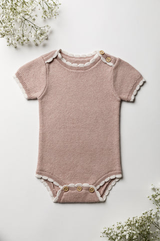 Knitted pink bodysuit with a cream scalloped trim and button fastening