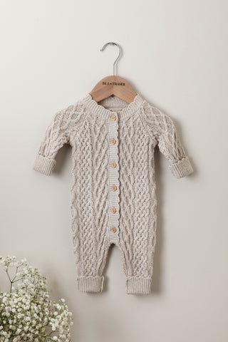 Neutral grey cable knit baby romper on an Isla & Fraser wooden hanger