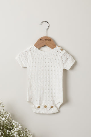 White Pointelle Knit Baby Bodysuit on an Isla & Fraser wooden hanger